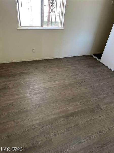 5284 Wellesley Ave, Las Vegas, NV 89122 - empty room featuring plenty of natural light, dark wood-style floors, and baseboards
