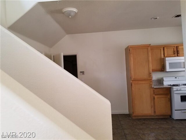 9937 La Paca Ave, Las Vegas, NV 89117 - kitchen featuring white appliances, dark tile patterned floors, light countertops, and lofted ceiling