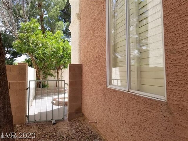 9937 La Paca Ave, Las Vegas, NV 89117 - view of property exterior with stucco siding and a gate