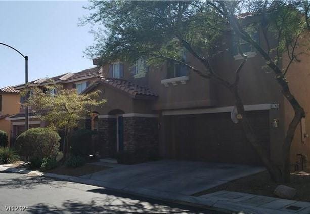 8749 Brilliant Star Dr, Las Vegas, NV 89178 - view of front of home featuring concrete driveway, an attached garage, a tile roof, and stucco siding