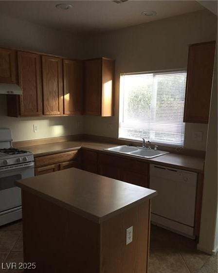 8749 Brilliant Star Dr, Las Vegas, NV 89178 - kitchen with gas range oven, dishwashing machine, a sink, a kitchen island, and light tile patterned floors