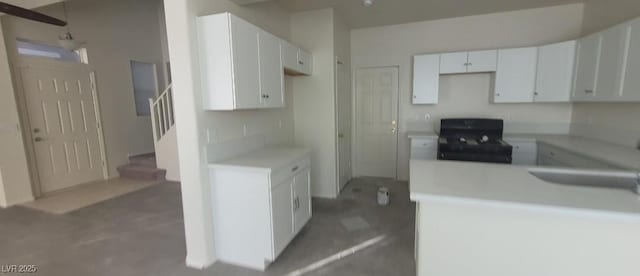 8695 Canfield Canyon Ave, Las Vegas, NV 89178 - kitchen with black range, a sink, light countertops, and white cabinetry
