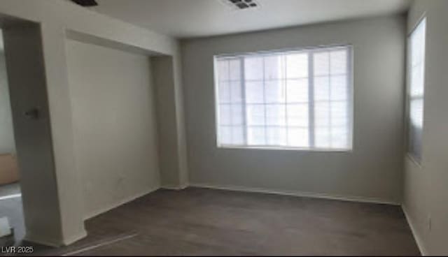 8695 Canfield Canyon Ave, Las Vegas, NV 89178 - empty room with healthy amount of natural light, baseboards, and dark wood-style floors