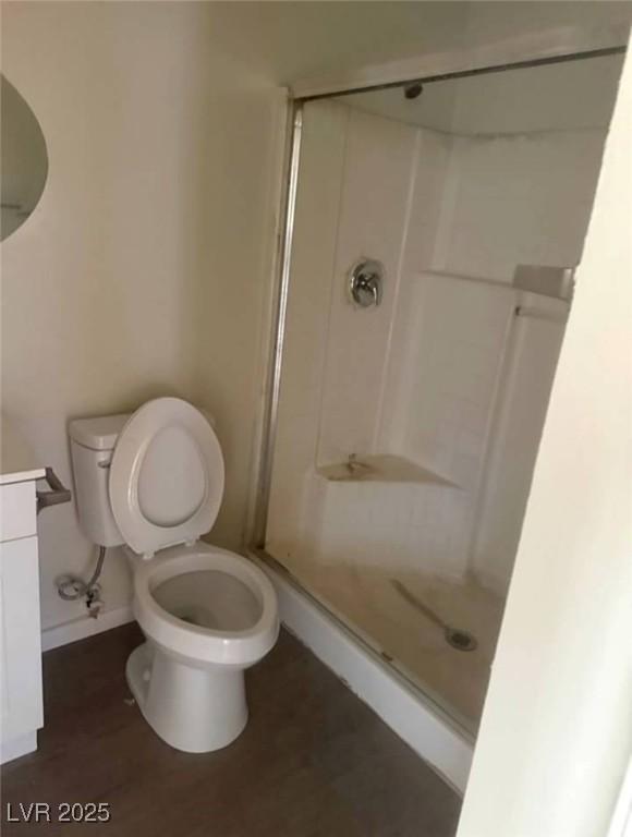 5115 Blossom Ave, Las Vegas, NV 89142 - bathroom featuring a shower stall, toilet, and wood finished floors