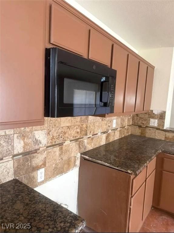 5115 Blossom Ave, Las Vegas, NV 89142 - kitchen with black microwave, decorative backsplash, dark stone counters, and a peninsula
