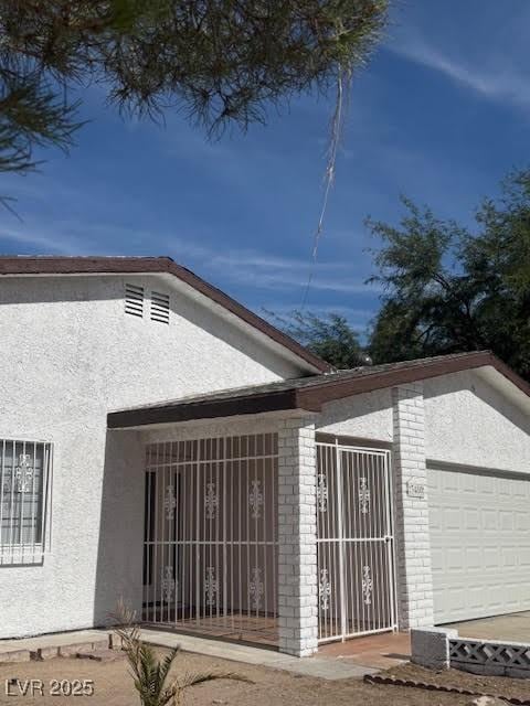 3480 E Hacienda Ave, Las Vegas, NV 89120 - view of home's exterior with stucco siding, a garage, and brick siding