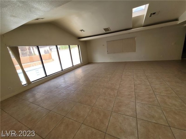 3480 E Hacienda Ave, Las Vegas, NV 89120 - empty room with tile patterned flooring, vaulted ceiling, and a textured ceiling