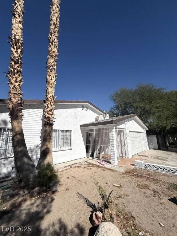 3480 E Hacienda Ave, Las Vegas, NV 89120 - view of side of property with a garage, stucco siding, and an outbuilding