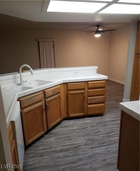 2720 Knightsbridge Rd, Henderson, NV 89074 - kitchen with a ceiling fan, tile countertops, a sink, dark wood finished floors, and brown cabinets