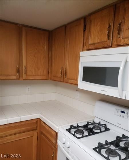 2720 Knightsbridge Rd, Henderson, NV 89074 - kitchen featuring white appliances, brown cabinets, and tile countertops