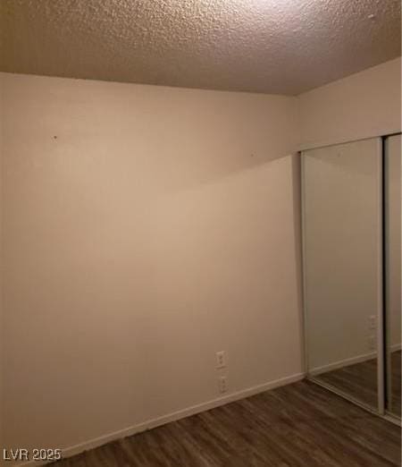2720 Knightsbridge Rd, Henderson, NV 89074 - unfurnished bedroom featuring dark wood-style flooring, a textured ceiling, a closet, and baseboards