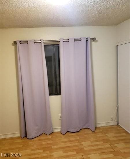 2720 Knightsbridge Rd, Henderson, NV 89074 - unfurnished bedroom featuring light wood-style floors, baseboards, and a textured ceiling