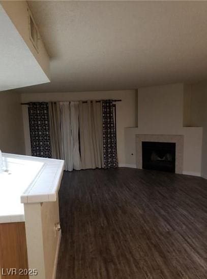 2720 Knightsbridge Rd, Henderson, NV 89074 - living area featuring dark wood-style flooring, a fireplace, and baseboards