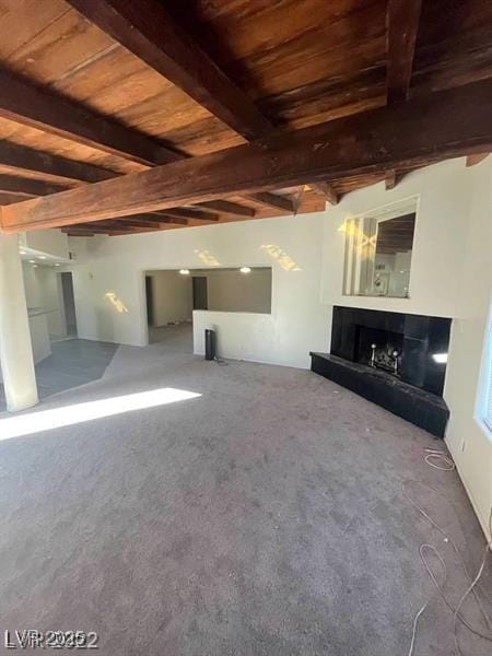 1413 Bryn Mawr Ave, Las Vegas, NV 89102 - unfurnished living room featuring wooden ceiling with exposed beams, a tile fireplace, and carpet