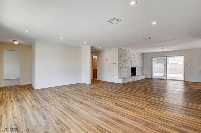 3386 El Camino Real, Las Vegas, NV 89121 - unfurnished living room featuring light wood finished floors, recessed lighting, baseboards, and a large fireplace
