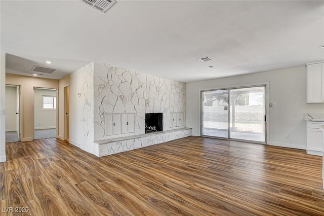 3386 El Camino Real, Las Vegas, NV 89121 - unfurnished living room featuring wood finished floors, plenty of natural light, a large fireplace, and baseboards