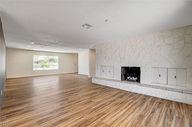 3386 El Camino Real, Las Vegas, NV 89121 - unfurnished living room featuring wood finished floors, a fireplace with raised hearth, baseboards, and recessed lighting