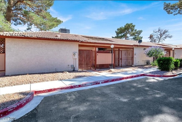 417 N Lamb Blvd Unit E, Las Vegas, NV 89110 - view of front facade featuring stucco siding, a gate, a tile roof, cooling unit, and a fenced front yard
