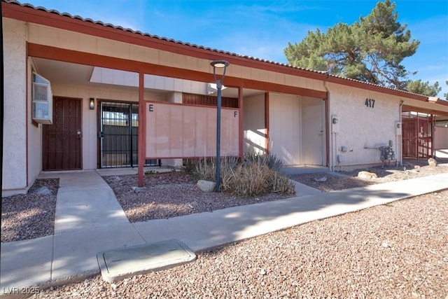 417 N Lamb Blvd Unit E, Las Vegas, NV 89110 - view of exterior entry featuring a gate, a tile roof, and stucco siding