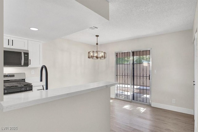 417 N Lamb Blvd Unit E, Las Vegas, NV 89110 - kitchen with appliances with stainless steel finishes, baseboards, light wood finished floors, light stone counters, and white cabinets
