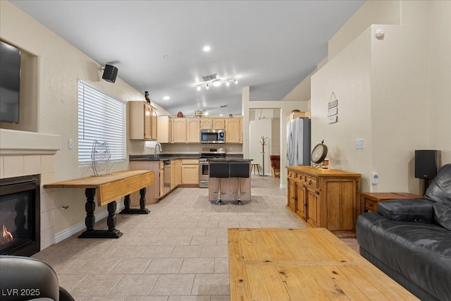 5937 Round Castle St, Las Vegas, NV 89130 - living room with a tiled fireplace, light tile patterned flooring, vaulted ceiling, and baseboards