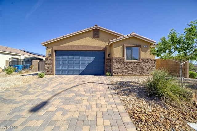 2099 Port Royal Dr, Laughlin, NV 89029 - view of front of house with stone siding, stucco siding, decorative driveway, and an attached garage