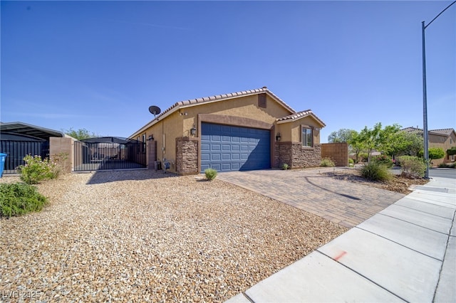 2099 Port Royal Dr, Laughlin, NV 89029 - view of front of property featuring a gate, a garage, stucco siding, and decorative driveway