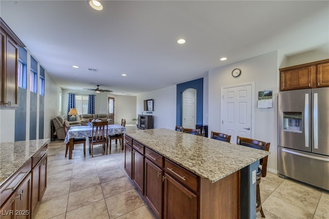 2099 Port Royal Dr, Laughlin, NV 89029 - kitchen featuring stainless steel fridge with ice dispenser, a kitchen breakfast bar, arched walkways, recessed lighting, and a center island
