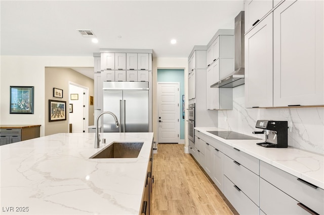 3395 Stone View Ave, Henderson, NV 89044 - kitchen with wall chimney exhaust hood, stainless steel appliances, a sink, light stone countertops, and light wood-type flooring