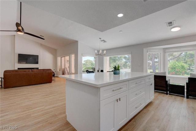 3040 Hidden Treasure Dr, Las Vegas, NV 89134 - kitchen featuring light wood-style floors, open floor plan, white cabinetry, recessed lighting, and vaulted ceiling