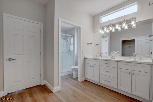 3040 Hidden Treasure Dr, Las Vegas, NV 89134 - bathroom with toilet, a shower stall, double vanity, wood finished floors, and baseboards