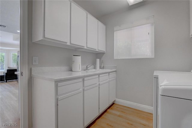 3040 Hidden Treasure Dr, Las Vegas, NV 89134 - laundry area with light wood-type flooring, baseboards, washer / dryer, and cabinet space