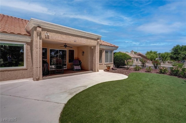 3040 Hidden Treasure Dr, Las Vegas, NV 89134 - back of house with a ceiling fan, a patio area, a lawn, stucco siding, and a tile roof