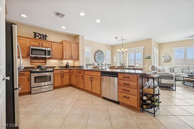 2453 Vivid Sky Pl, Henderson, NV 89044 - kitchen featuring stainless steel appliances, open floor plan, a chandelier, a sink, and a peninsula