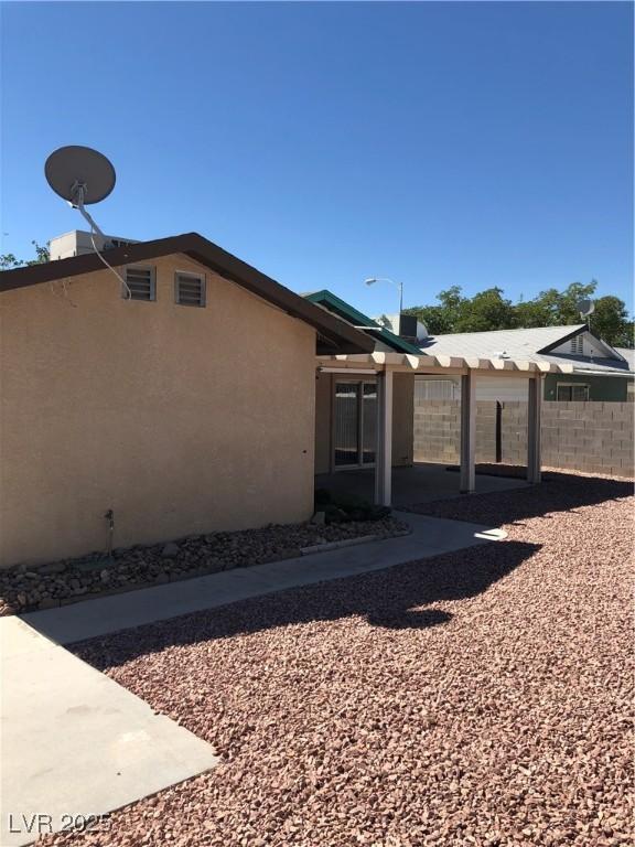 6196 W University Ave, Las Vegas, NV 89103 - view of side of home with stucco siding and a patio