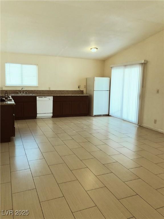 6196 W University Ave, Las Vegas, NV 89103 - kitchen featuring white appliances, healthy amount of natural light, a sink, and dark brown cabinetry