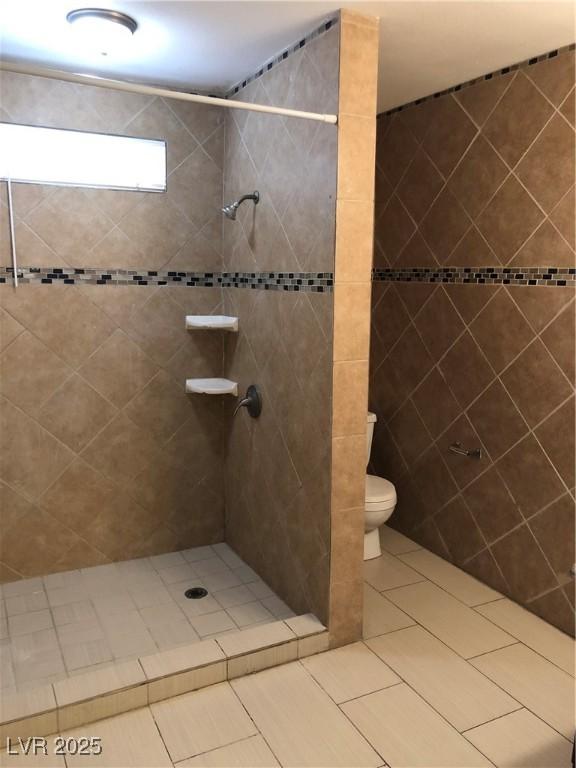 6196 W University Ave, Las Vegas, NV 89103 - bathroom featuring tiled shower, toilet, and tile patterned flooring