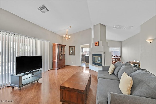 6125 Desert Haven Rd, Las Vegas, NV 89130 - living area with a chandelier, wood finished floors, high vaulted ceiling, a multi sided fireplace, and baseboards