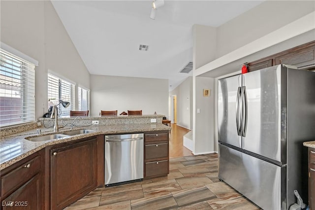 6125 Desert Haven Rd, Las Vegas, NV 89130 - kitchen with appliances with stainless steel finishes, a sink, high vaulted ceiling, and light stone counters