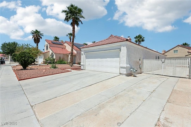 628 Bay Bridge Dr, North Las Vegas, NV 89032 - view of front of house with a gate, a tile roof, concrete driveway, stucco siding, and an attached garage