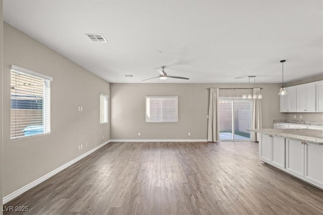 7051 Denio Island St, North Las Vegas, NV 89084 - unfurnished living room with wood finished floors, ceiling fan, and baseboards