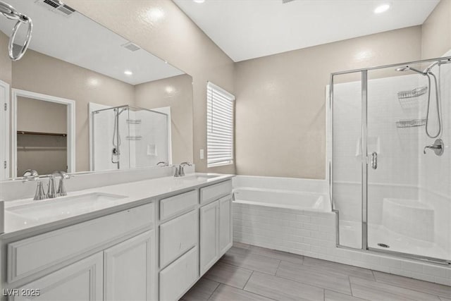 7051 Denio Island St, North Las Vegas, NV 89084 - bathroom with a shower stall, a garden tub, double vanity, and a walk in closet