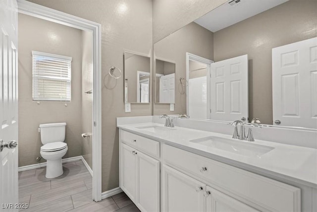 7051 Denio Island St, North Las Vegas, NV 89084 - bathroom with toilet, double vanity, and baseboards