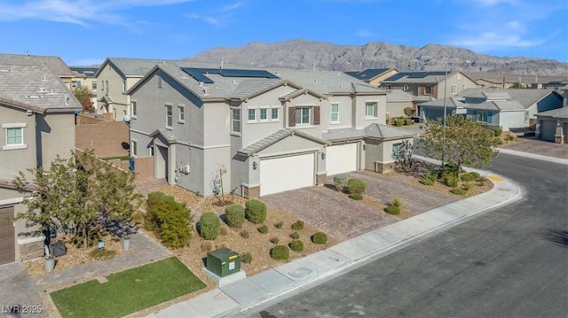 7051 Denio Island St, North Las Vegas, NV 89084 - multi unit property with a residential view, an attached garage, a mountain view, decorative driveway, and stucco siding