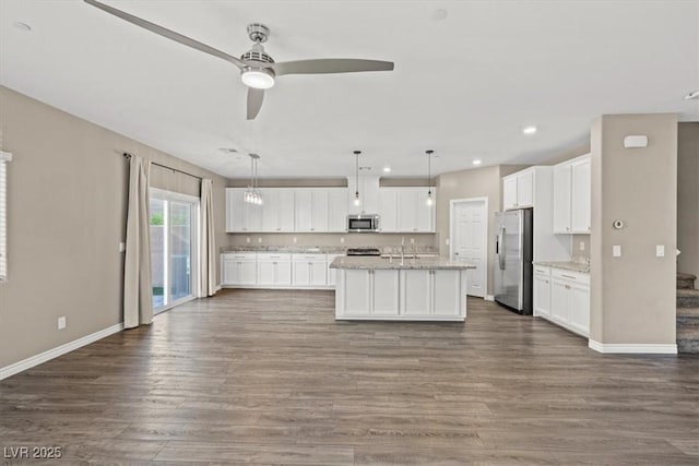 7051 Denio Island St, North Las Vegas, NV 89084 - kitchen with appliances with stainless steel finishes, white cabinets, a ceiling fan, dark wood-style floors, and baseboards