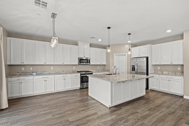 7051 Denio Island St, North Las Vegas, NV 89084 - kitchen with appliances with stainless steel finishes, a sink, recessed lighting, white cabinetry, and wood finished floors