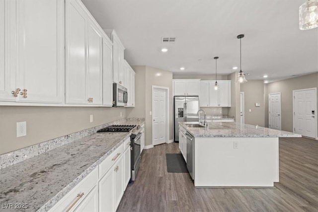 7051 Denio Island St, North Las Vegas, NV 89084 - kitchen with appliances with stainless steel finishes, white cabinets, dark wood-style flooring, and recessed lighting