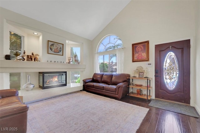 8224 Fawn Meadow Ave, Las Vegas, NV 89149 - living room with a glass covered fireplace, dark wood-style floors, and high vaulted ceiling