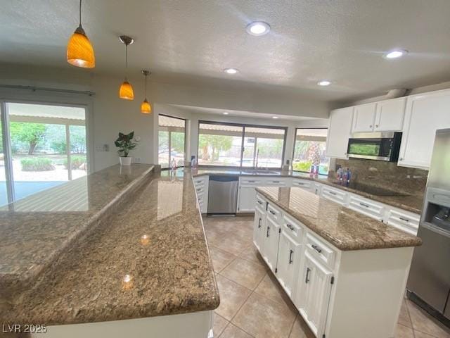 6315 Eldora Ave, Las Vegas, NV 89146 - kitchen featuring stainless steel appliances, a kitchen island, light tile patterned floors, tasteful backsplash, and recessed lighting