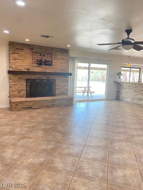 6315 Eldora Ave, Las Vegas, NV 89146 - unfurnished living room featuring a stone fireplace, a ceiling fan, tile patterned floors, and recessed lighting
